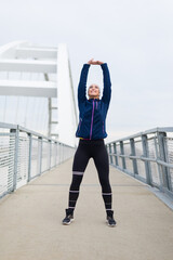 Young woman exercising on the bridge footpath