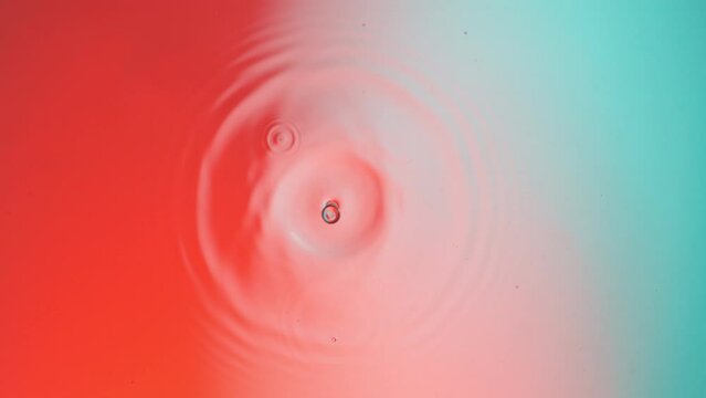 Super slow motion of water drop falling on color background. Filmed on high speed cinema camera, 1000 fps.