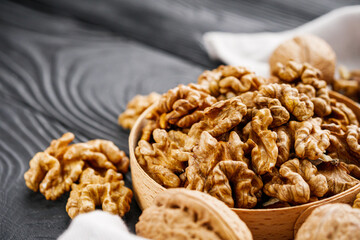 dried walnuts on a black rustic wooden background