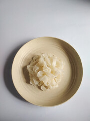 boiled kwetiaw on a plate on a white background, top view.