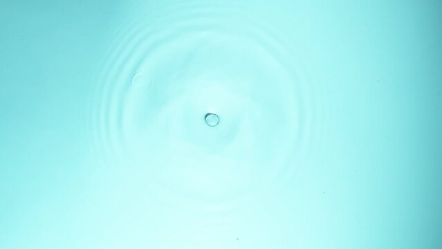 Super slow motion of water drop falling on light blue background. Filmed on high speed cinema camera, 1000 fps.