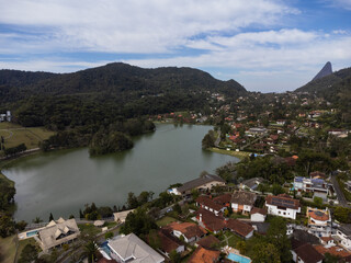 Fototapeta premium Aerial view of Granja Comary, Carlos Guinle neighborhood in the city of Teresópolis. Mountain region of Rio de Janeiro, Brazil. Drone photo. Houses, lake and hills and mountains
