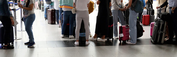 crowded airport with people with suitcases during the summer season