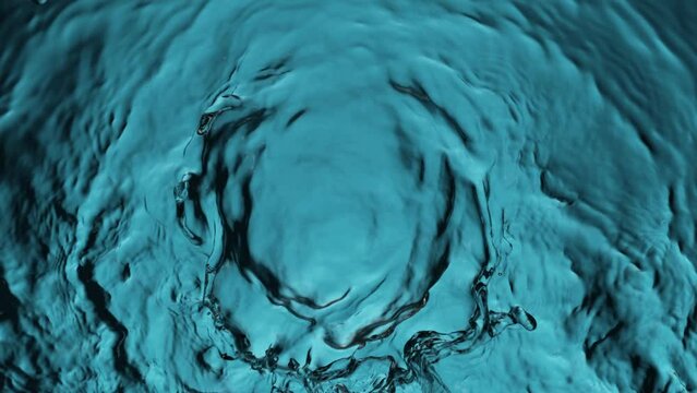 Super slow motion of water surface on light blue background. Filmed on high speed cinema camera, 1000 fps.