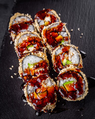 delicious sushi rolls on a black stone background