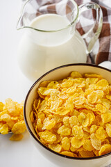 crispy golden cornflakes on a white acrylic background