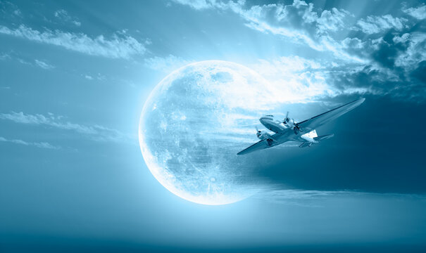 Vintage type old metallic propeller airplane in the sky with full Moon "Elements of this image furnished by NASA "