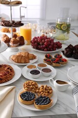 Variety of snacks on white marble table in buffet style indoors