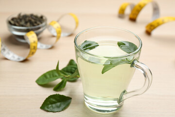 Obraz na płótnie Canvas Diet herbal tea with green leaves on wooden table