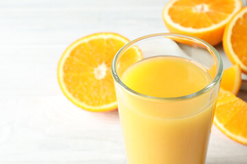 Glass of orange juice and fresh fruits on white wooden table, closeup