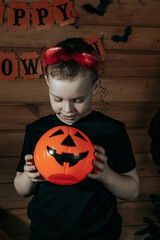 Halloween kids. Cute little boy, child in suit with orange Jack O Lantern candy bucket. Happy Halloween. Halloween background.