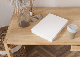 White book cover mock up with coffee cup, vase and other home accessories on wooden table. Blank template for your design. Top view, close-up. Book, catalogue cover presentation. 3D rendering.