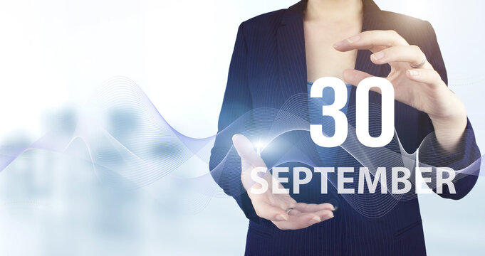 September 30th. Day 30 of month, Calendar date. Hand hold virtual hologram calendar date with digital wave.  Autumn month, day of the year concept.