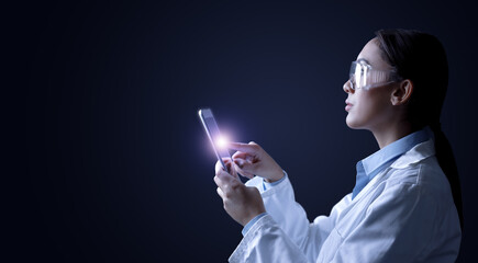 Side portrait of young female doctor touching tablet computer isolated on black background with empty space for text and image. - obrazy, fototapety, plakaty