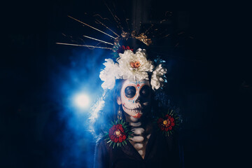 Woman with mexican skull halloween makeup on face. Day of the dead aka Dia de los Muertos and...