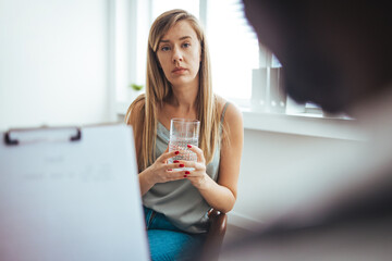 Caring African American psychotherapist consoling young woman during a therapeutic session at his office. A young frustrated girl meets with a therapist to discuss her struggles