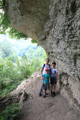 Mother with sons in grotto of Belaya river valley