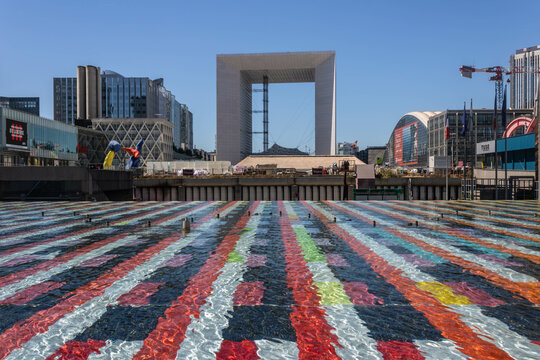Paris, France - July 15th 2022: Amazing perspective of Agam's  monumental fountain, La Defense district with GrandeArche