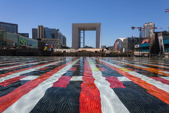 Paris, France - July 15th 2022: Amazing perspective of Agam's  monumental fountain, La Defense district with GrandeArche
