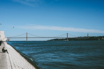 Long Ponte 25 de Abril bridge in Lisbon over the Tagus river with a clear sky in the background