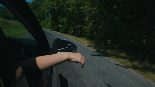 Woman's hand outside car window. Summer vacations concept.