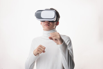 Young man using virtual reality headset looking up and interacting with Facebook Youtube Steam VR content. Isolated on a white background studio portrait. VR, future, gadgets, technology, concept