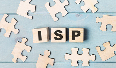 Blank puzzles and wooden cubes with the text ISP Internet Service Provider lie on a light blue background.