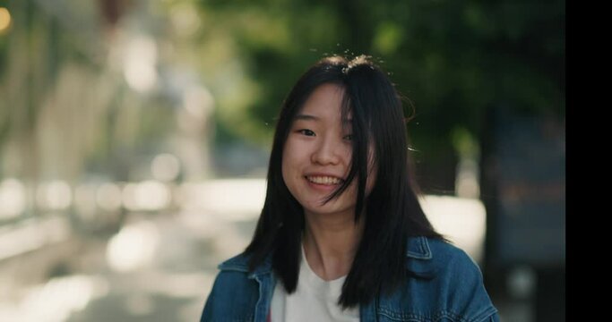 Asian girl walking, turning to the camera and smiling