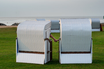Older couple holding hands while sitting in beach chairs in Cuxhaven, Germany.