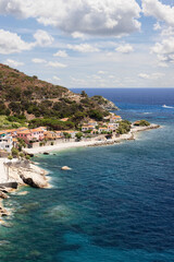 Vertical shot of one of the many picturesque villages on the coast of Elba Island with a sandy...