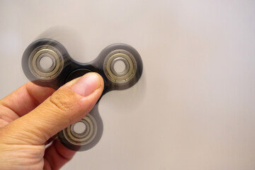 Fidget spinner turning in man hand with motion blur close up view