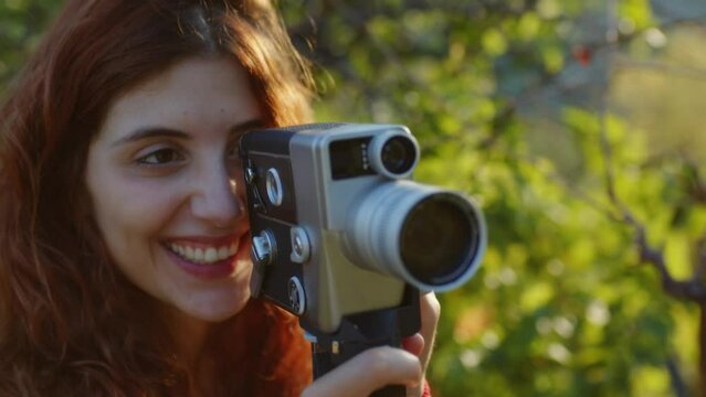 Happy girl enjoy the nature with her film 8mm camera vintage