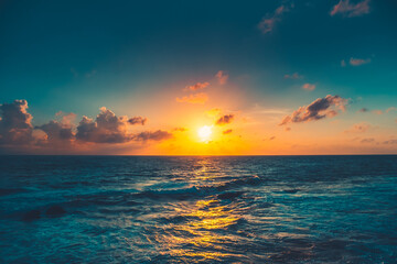 Bright orange sunset sun over blue ocean. Sunlight reflected in dark water. Amazing summer scenery....