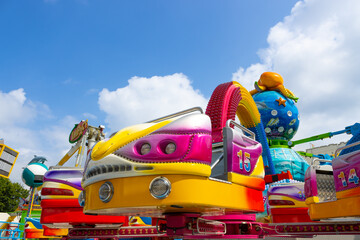 A gondola belonging to an octopus ride on an arm full of lights on the funfair in Oss city (North Brabant, the Netherlands). The attraction has bright colors and has an ocean theme.