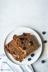 Slices of banana bread with blueberries served on a plate on a gray background. Top view.