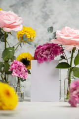 Blank white paper greeting card mock up. Pink and yellow flowers in vases with copy space. Hydrangea, dahlias and eucalyptus.