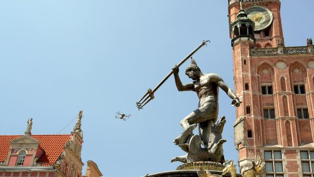 Fountain of Neptune near the building of the Town Hall of the Main City in the Long Market of Gdansk, a drone in the sky shoots a historical monument, a masterpiece of mannerism and rococo in Poland