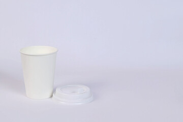 there is a glass, next to it lies a lid on a white background. horizontal photo