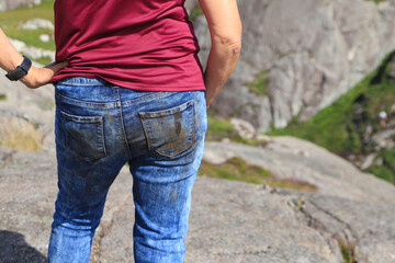 A woman has dirty jeans from hiking on the difficult Brufjell hiking trail - Norway