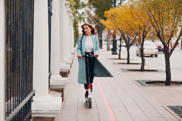 Young woman with electric scooter at the city.