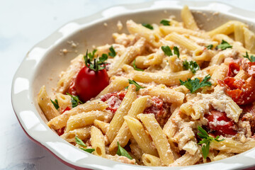 cooking recipe Fetapasta with cherry tomatoes, feta cheese, garlic and thyme on white plate. top view
