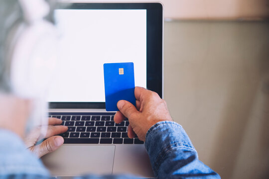 Cropped image of man buying online with credit card at home
