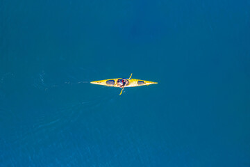Yellow kayak rowers on blue turquoise water sea, sunny day. Concept extreme sport, aerial top view © Parilov