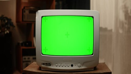 Old television with green chroma key screen at home. Close-up of vintage tv in living room, nostalgia.