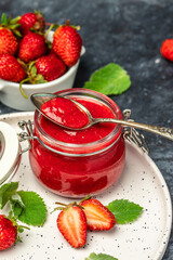 Strawberry jam in the glass jar, Homemade strawberry marmelade and fruits on a dark background, vertical image. top view. place for text