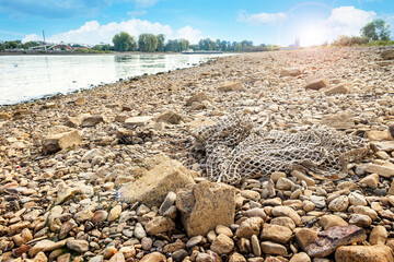 Dry river Rhine with old net on pebble stones - Climate change and the impact to a river