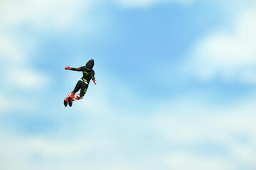 Naklejka na ściany i meble Miniature people toy figure photography. A men doing sky diving jump in cloudy bright day