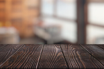 Wooden board empty table in front of blurred background. Perspective dark brown wood over blur in coffee shop which can be used for display or montage your products. Mock up for display of product.
