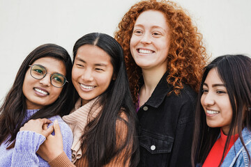 Fototapeta premium Happy diverse young women hugging each other outdoor - Multiethnic female friends