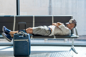 man in the airport sleeps on the armchairs - 524293501